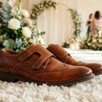 Young boy wearing dark navy suit and polished black leather wedding shoes.