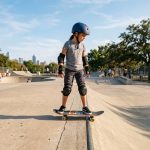 Beginner skateboarder with safety gear preparing to drop into a ramp in Texas.