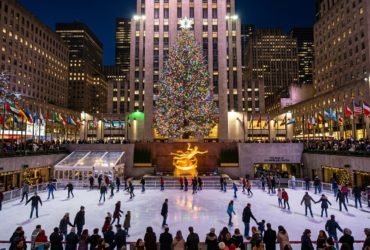 Rockefeller Center Christmas tree lit up at night above the ice rink