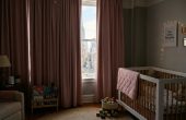Pastel pink blackout curtains blocking bright NYC sunlight in a child’s room.
